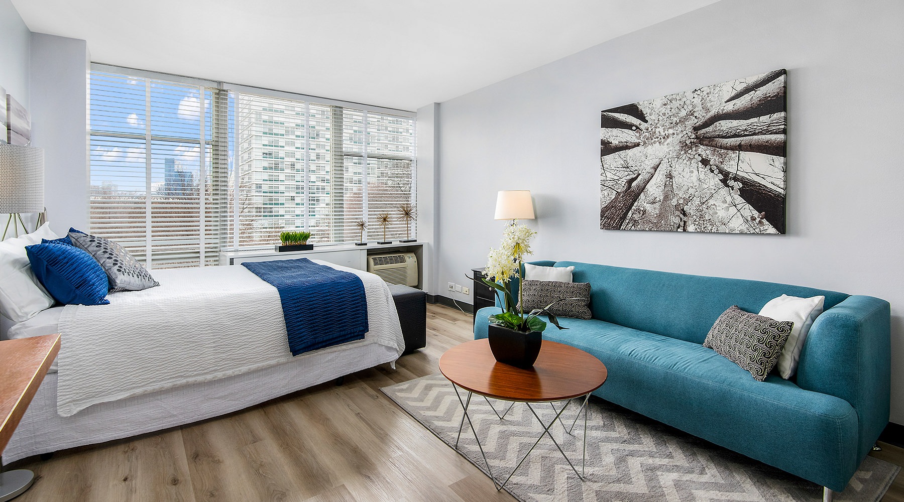 Furnished bedroom with large window view Furnished bedroom with large window view